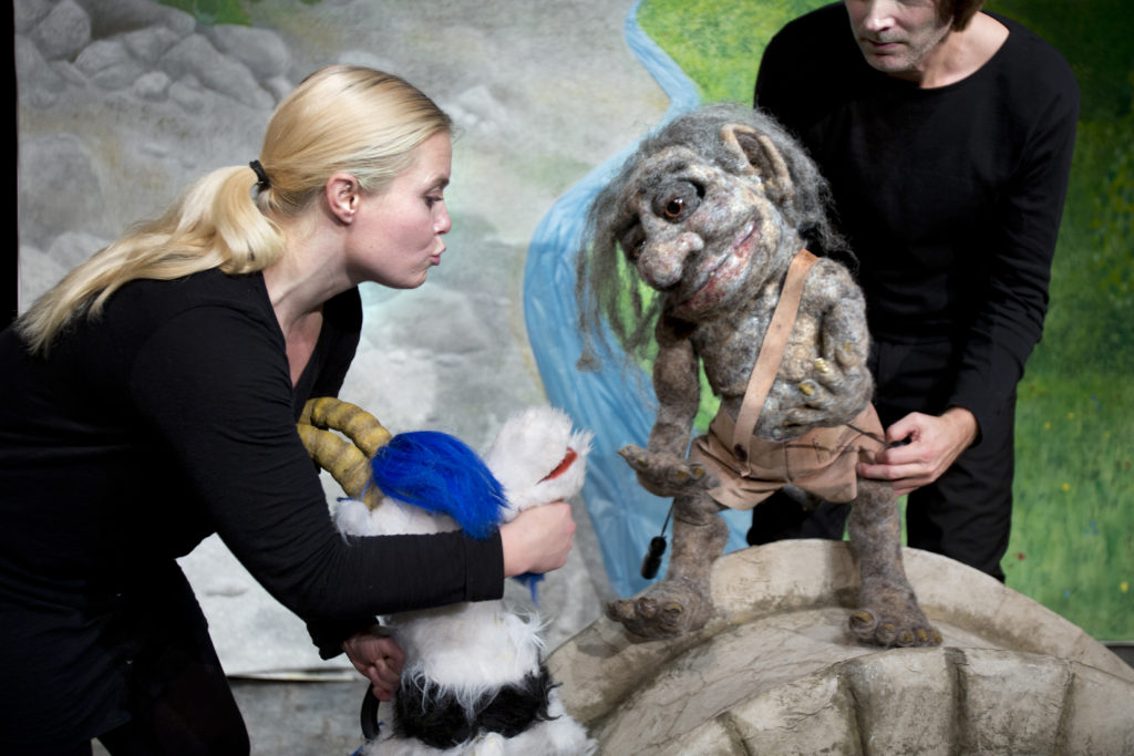 Teaterföreställning "Bockarna Bruse" med en kvinna, en man och två dockor i form av en bock och ett troll.
