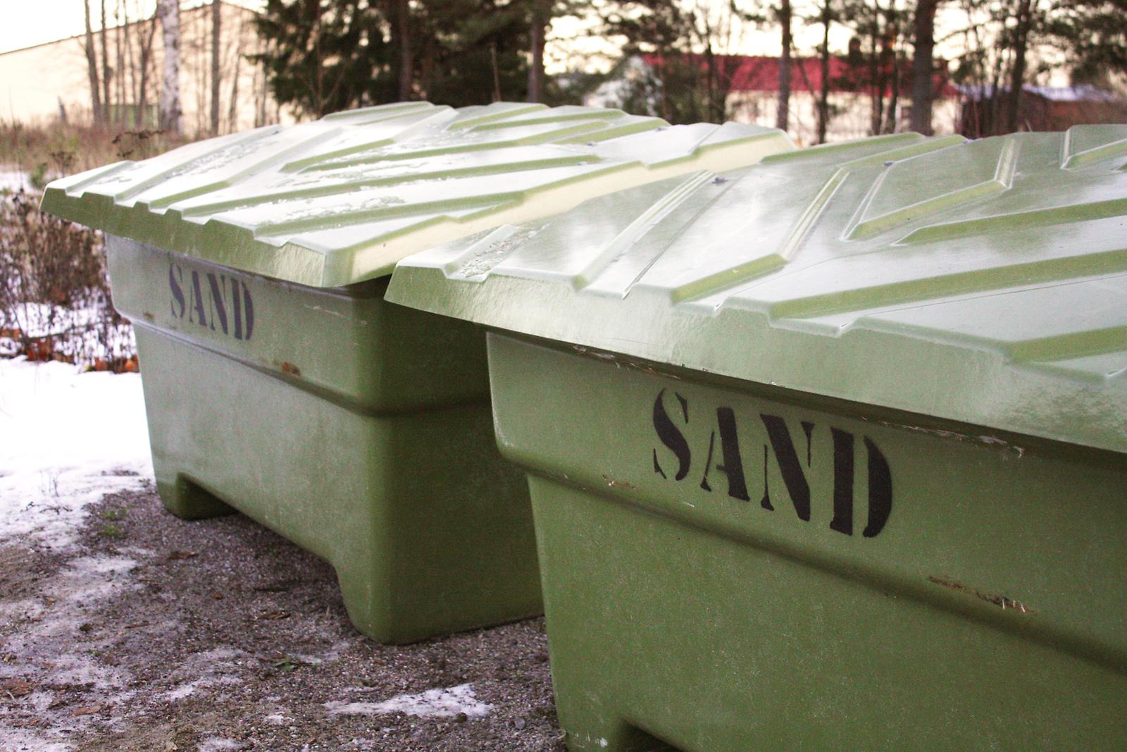 Två gröna lådor med sand.