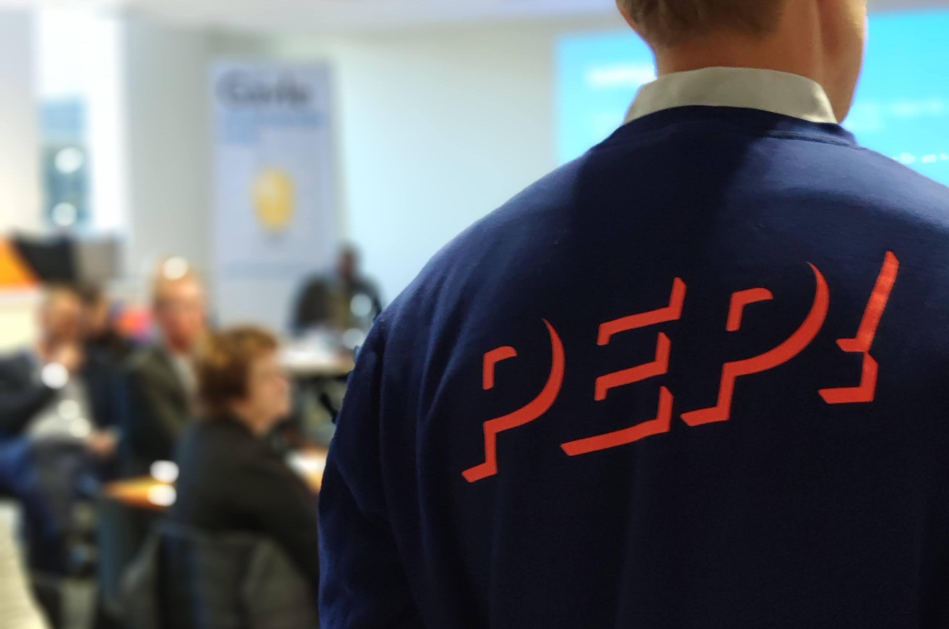 Man med en tröja med texten "PEP!" på ryggen.