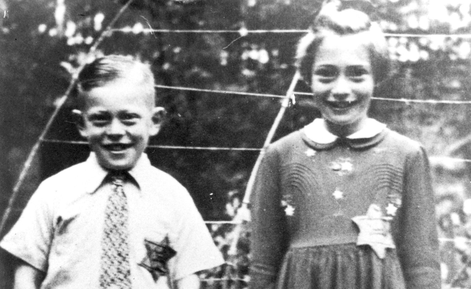 Ett svartvitt fotografi med en pojke och en flicka med så kallade judestjärnor på kläderna.
