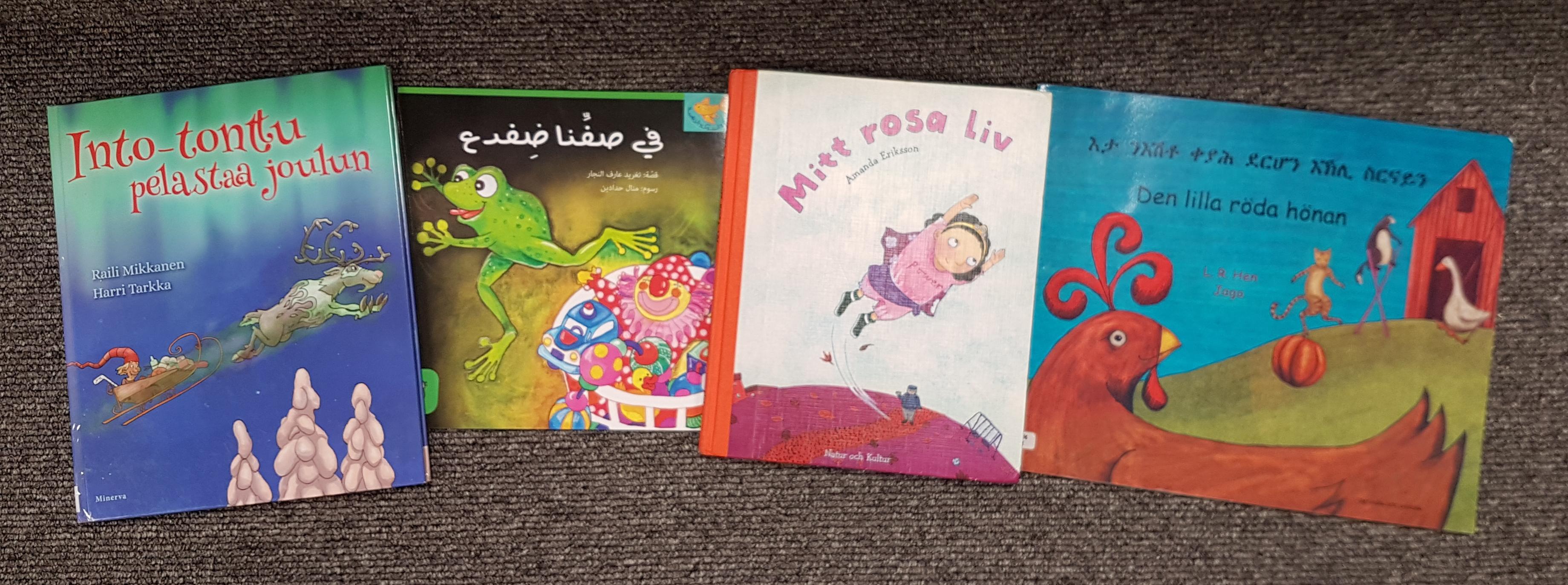 Fyra bilderböcker: en på finska, en på arabiska, en på svenska och en på tigrinska.
