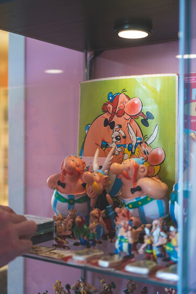 Asterix- och Obelixfigurer i en glashylla.