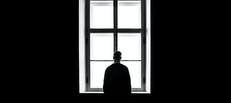 en man som står vid ett fönster