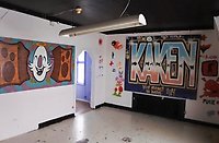 Ett tomt rum med lekfulla målningar på väggarna. På ena väggen är det målat "Kåken" med stora bokstäver.