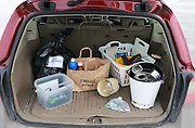 Sopor sorterade i olika behållare i bakluckan på en bil.