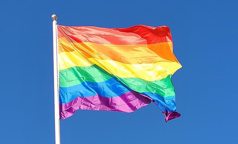Flagga i regnbågens färger vajar i vinden.
