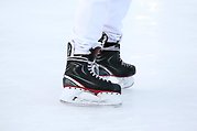 Ett par skridskobeklädda fötter på en is.