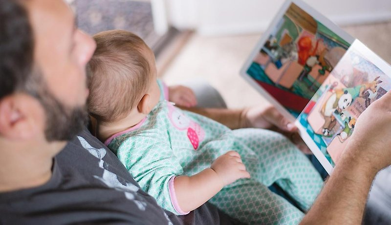 en pappa som läser en bok för sitt barn
