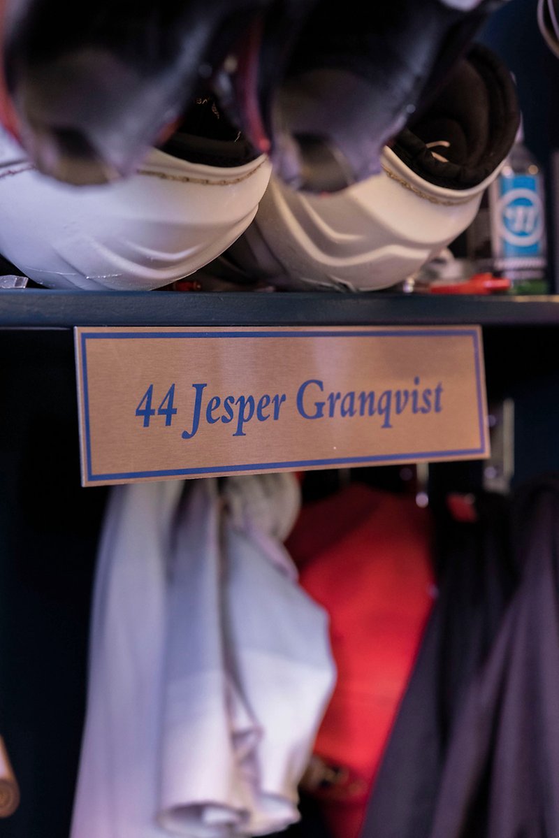 En namnskylt som det står "44 jesper Granqvist" på sitter på en klädhylla.