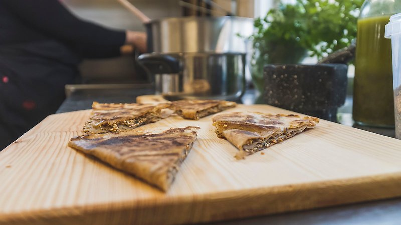Libabröd med za'atar ligger på en skärbräda i ett kök.